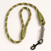 Correa reflectante para perros PetBaby de 1.2 metros en color verde oliva con patrón de seguridad blanco. Destaca su diseño de cuerda gruesa tipo escalada, un mango acolchado para mayor comodidad y un resorte amortiguador de acero integrado para suavizar los tirones fuertes.